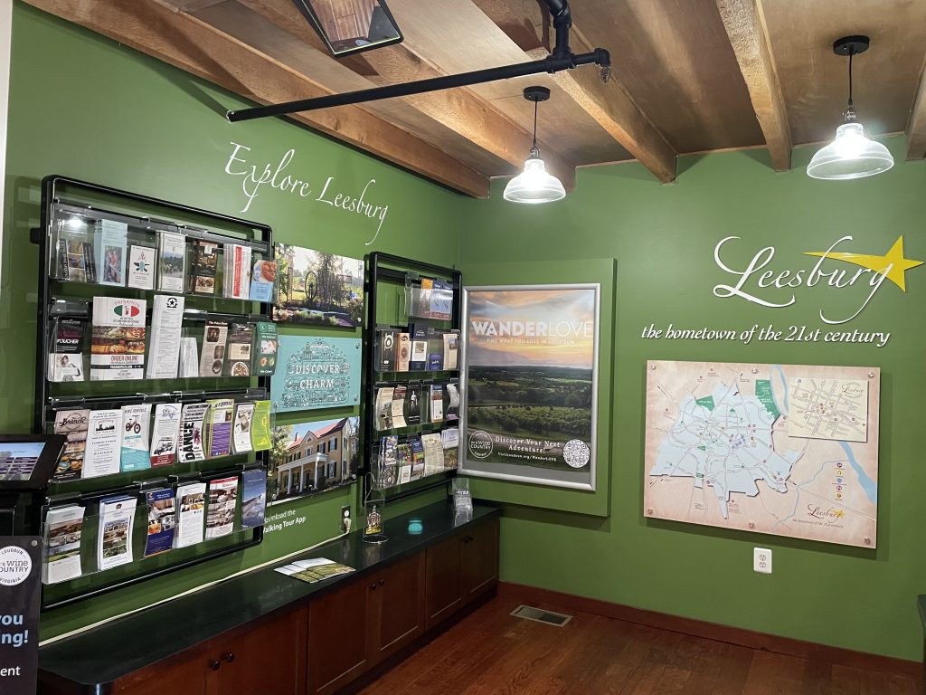 Interior of Visitor Center with racks of brochures and a large map of Leesburg